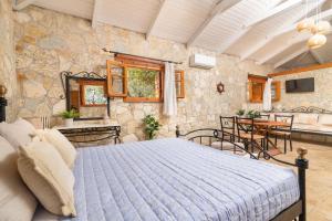 a bedroom with a bed and a stone wall at Villa Sea Stone by Villa Plus in Makris Gialos