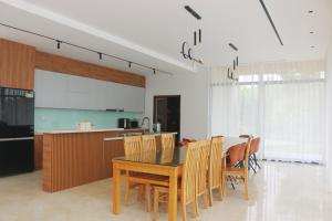- une cuisine et une salle à manger avec une table et des chaises dans l'établissement Moon Villa- Melorita Hòa Lạc, à Ðào Lãng