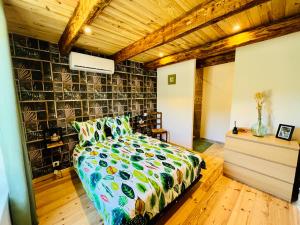 a bedroom with a bed with a colorful comforter at Le domaine des Oliviers ALES Piscine Jacuzzi Sauna in Alès +86 photos