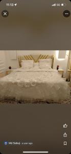 Schlafzimmer mit einem Bett mit weißer Bettwäsche und Kissen in der Unterkunft فواصل الشمال للشقق المخدومة in Rafha