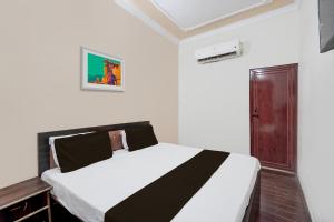 メーラトにあるOYO Hotel Maharaja Palaceのベッドルーム1室(白黒のベッド1台付)