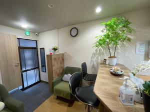 東京的住宿－平安旅馆家庭间，一间设有桌椅和墙上时钟的房间