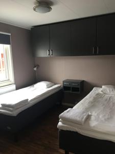 two beds in a room with black cabinets at Land-Inn Motel in Rosersberg