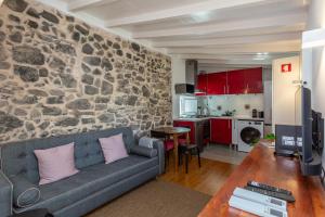 sala de estar con sofá y pared de piedra en Palace Guest Inn, en Queluz