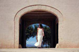 a woman in a dress standing in an archway at Es Figueral Nou Hotel Rural & Spa - Adults Only - Over 12 in Montuiri