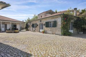 a cobblestone driveway in front of a building at Charming granite cottage in beautiful surroundings in Casal Diz
