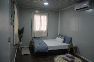 ein kleines Schlafzimmer mit einem Bett und einem Fenster in der Unterkunft The Vanilla Cabin 