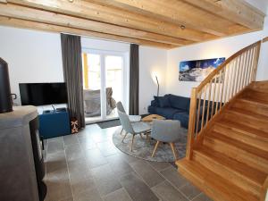 sala de estar con escalera y sofá azul en Luxurious Chalet in K tschach Mauthen near Ski Area, en Kötschach-Mauthen