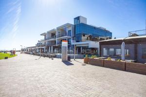 una strada di ciottoli con edifici sullo sfondo di Stylishly Decorated Beachfront apartment w Inverter, 202 Eden a Bloubergstrand
