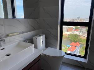 a bathroom with a sink and a toilet and a window at The Vincent Condo in Phnom Penh