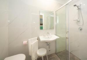 bagno bianco con lavandino e doccia di Hotel Marselli a Rimini