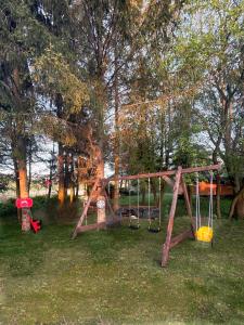 a park with a swing set in the grass at Cudomki in Piecki