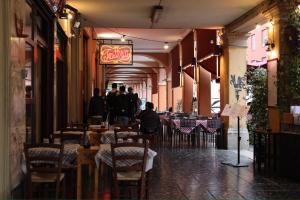 ボローニャにあるAppartamento Righi24のテーブルと椅子のあるレストランを歩く人々