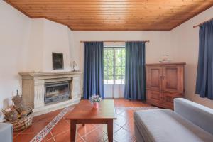 een woonkamer met een bank en een open haard bij Charming granite cottage in beautiful surroundings in Casal Diz