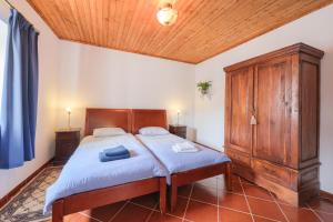 een slaapkamer met een groot bed met een houten hoofdeinde bij Charming granite cottage in beautiful surroundings in Casal Diz