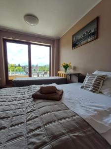 sypialnia z dużym łóżkiem i dużym oknem w obiekcie Noclegi PAŃSKA Góra w Andrychowie