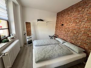 a bedroom with a brick wall and a bed at Landgasthof & Hotel Waldeck in Treuen