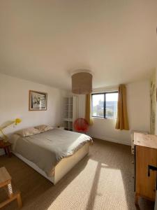 a bedroom with a large bed and a window at Joli appartement proche dunes d'Erdeven & Ria Etel in Erdeven