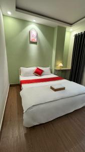 Ấp An Mỹ的住宿－AT Hotel Cần Thơ，卧室配有带红色枕头的大型白色床