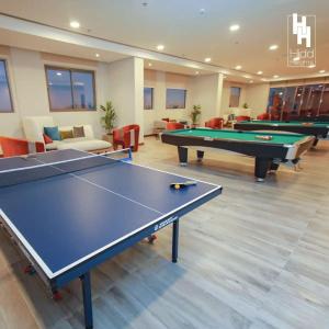uma sala de jogos com duas mesas de bilhar e sofás em Hidd heights bahrain em Ḩālat an Na‘īm