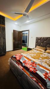 - une chambre avec un lit et un ventilateur de plafond dans l'établissement Rahat Arcade, à Islamabad