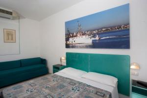 een slaapkamer met een bed en een boot in het water bij Hotel Marselli in Rimini