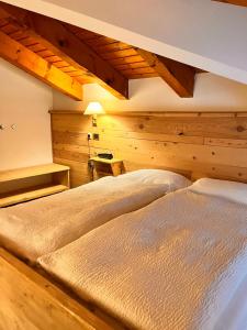 Tartano的住宿－阿爾伯格格蘭巴依塔酒店，卧室设有木墙和一张大床