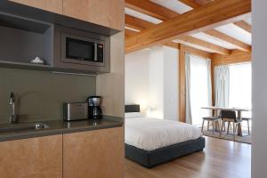 a bedroom with a bed and a kitchen with a sink at Ureta Landa Gaztelugatxe in Bakio