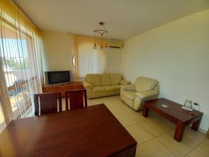 a living room with a couch and a table at Апартаменти СЪНИ БЕЙ in Sunny Beach