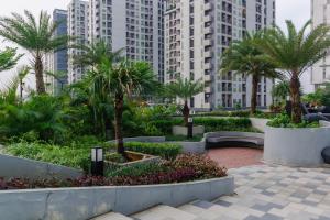 a park in a city with palm trees and buildings at Kamala by TwoSpaces Studio Akasa Apartment in Ciater-hilir