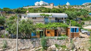 una casa en la parte superior de una pared de piedra en Vila Fjona, en Sarandë