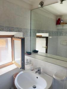 La salle de bains est pourvue d'un lavabo et d'un miroir. dans l'établissement Il Campanile, à Montemerano