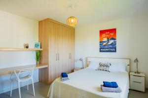 1 dormitorio con cama blanca y escritorio en Palm Biche Residence, en Trou aux Biches
