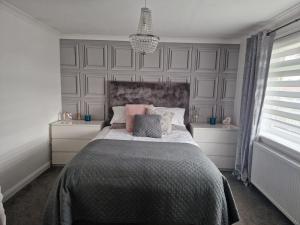 a bedroom with a large bed and a chandelier at Royal Troon Open 2024 in Kilwinning
