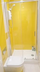 シェフィールドにあるCompact Studio Serviced Apartment Sheffield City Centre - Netflix, WiFi, Digital TVの黄色のバスルーム(トイレ、シャワー付)
