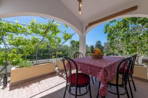 a porch with a table and chairs on a balcony at Charming holiday home Little House in Povljana