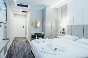 1 dormitorio con cama blanca y escritorio en ONKA OTELCİLİK TURİZM TİCARET LİMİTED ŞİRKETi en Estambul