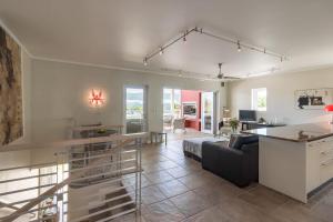 a living room with a couch and a table at Sunny Dry Mill Apartment on Thesen Islands in Knysna
