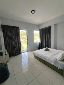 ein Schlafzimmer mit einem Bett und einem großen Fenster in der Unterkunft WESTAY Studio 1 Bedroom Near KK City Airport and Tg Aru Beach in Kota Kinabalu