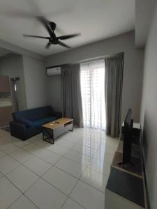 ein Wohnzimmer mit einem blauen Sofa und einem Deckenventilator in der Unterkunft WESTAY Studio 1 Bedroom Near KK City Airport and Tg Aru Beach in Kota Kinabalu