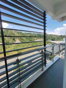 einen Balkon mit blauen Jalousien und Aussicht in der Unterkunft WESTAY Studio 1 Bedroom Near KK City Airport and Tg Aru Beach in Kota Kinabalu