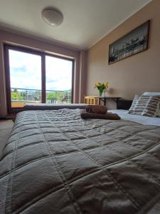 duże łóżko w sypialni z dużym oknem w obiekcie Noclegi PAŃSKA Góra w Andrychowie
