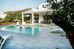 una piscina con sillas y una casa en Luxury Villa La Perla - Castellammare del golfo with Pool, Garden and Parking, en Castellammare del Golfo