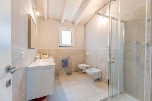 a bathroom with a toilet and a sink and a shower at Charming one-floor villa with garden, car parking in Albisola Superiore +21 photos