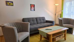 a living room with a couch and two chairs and a table at Ferienwohnung Feuerstein in Sassnitz