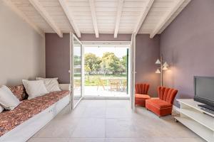 a bedroom with a bed and a tv and a patio at Charming one-floor villa with garden, car parking in Albisola Superiore