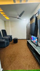 Il comprend un salon doté d'une télévision à écran plat et d'un canapé. dans l'établissement Rahat Arcade, à Islamabad