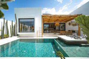 a villa with a swimming pool and a house at Villa Rosado Canggu in Tumbak Bayuh