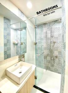 a bathroom with a sink and a glass shower at Sunshine Home Facing My KheBeach Da Nang in Danang