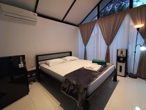 a bedroom with a bed and a large window at Niti Bhumi Villa in Borobudur